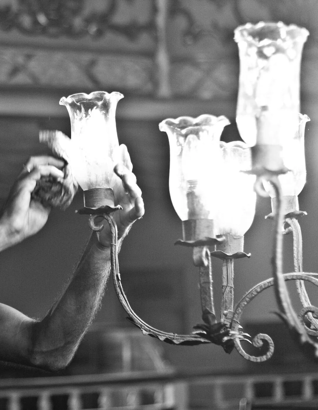 Expert craftsman cleaning antique chandelier